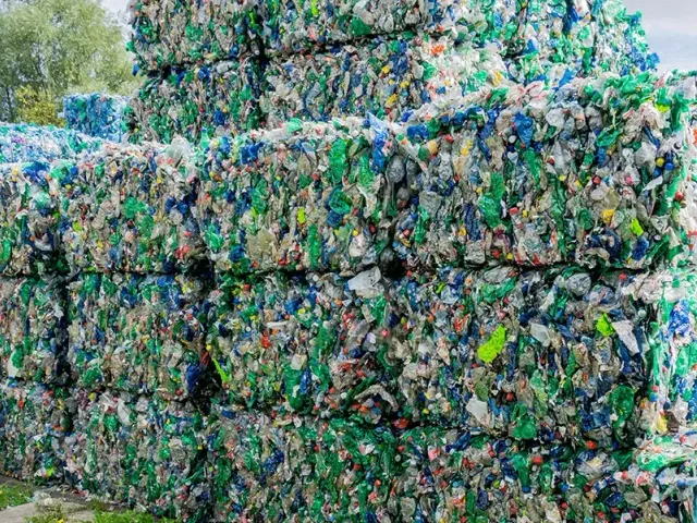 Stacked bales of mixed plastic material at a recycling site