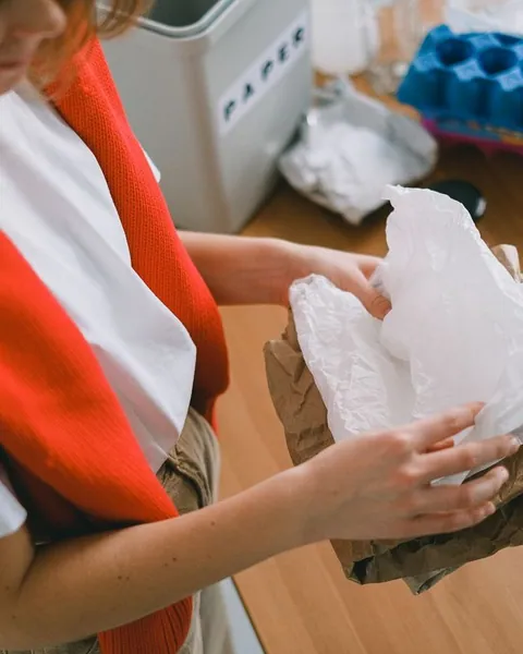 Person sorting paper and packaging waste at home